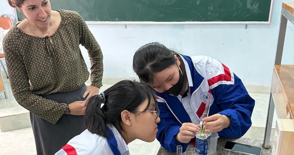 Teacher and two students conduct a science experiment