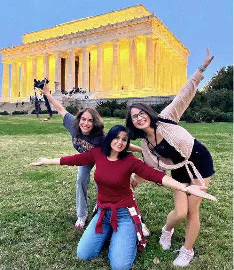 three people posing in front of the Lincoln Memorial