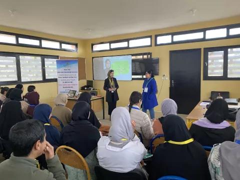 two teachers present to a classroom of girls