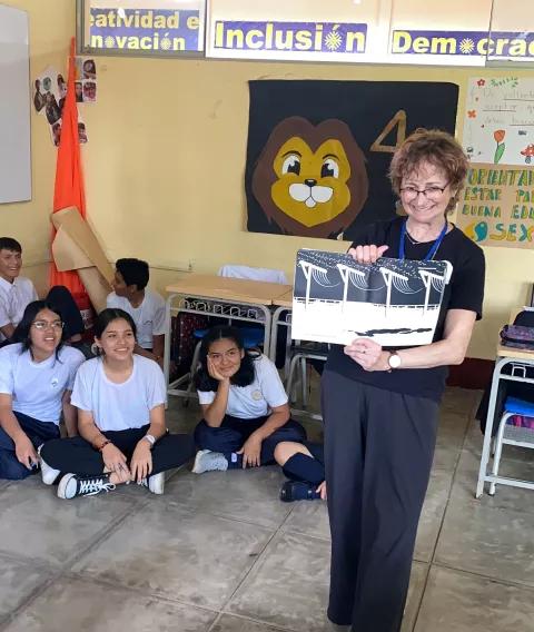 a teacher holds up a book of poetry