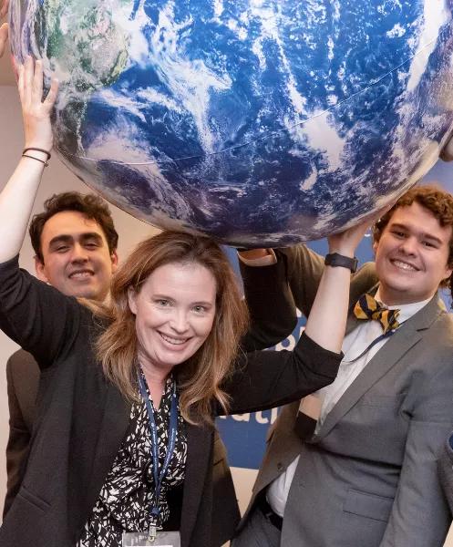 teachers lifting up a globe