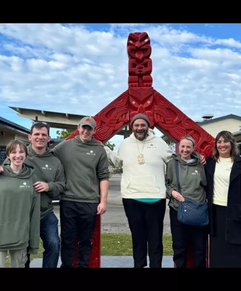 a group of people posing in front of a New Zealand monument