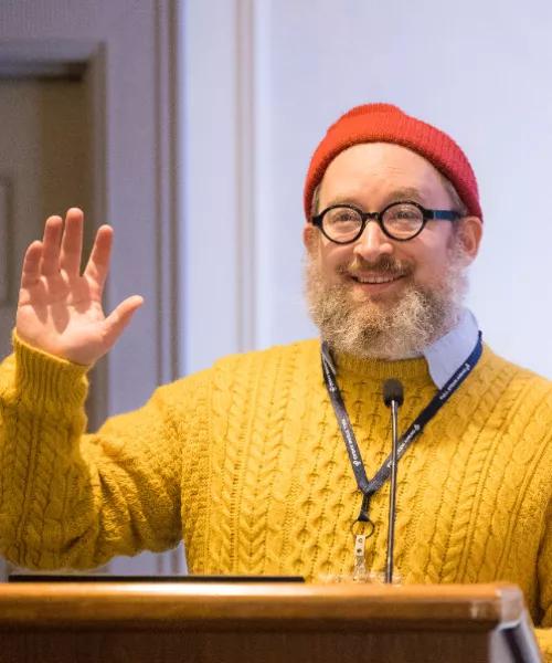 a person in a hat speaking at a podium